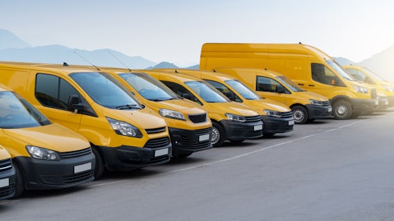 Yellow delivery vans parked in a row